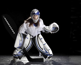 Young female ice hockey goalie in white jersey.